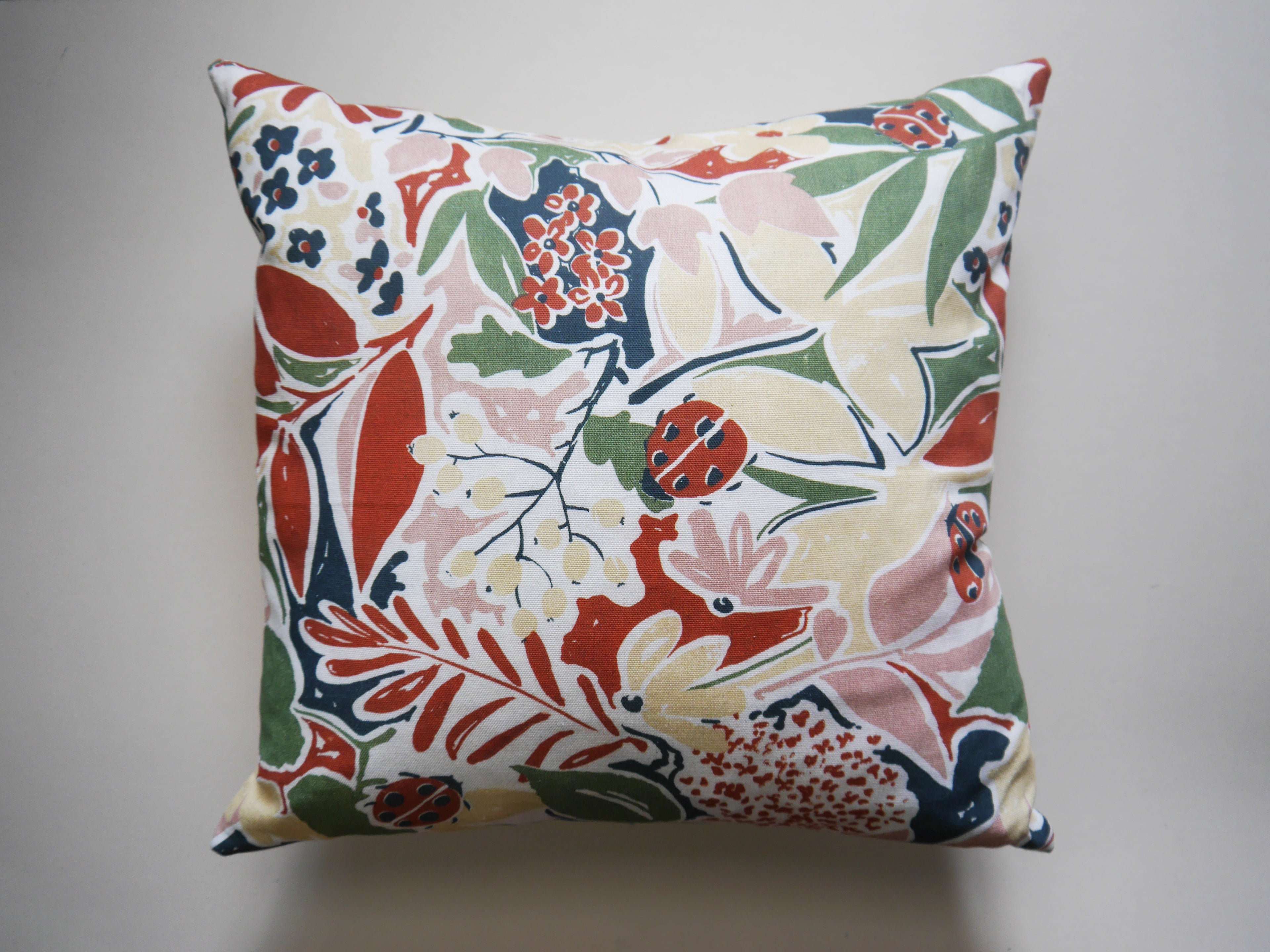 Nature's Delight Cushion: Ladybirds, Leaves, and Buds